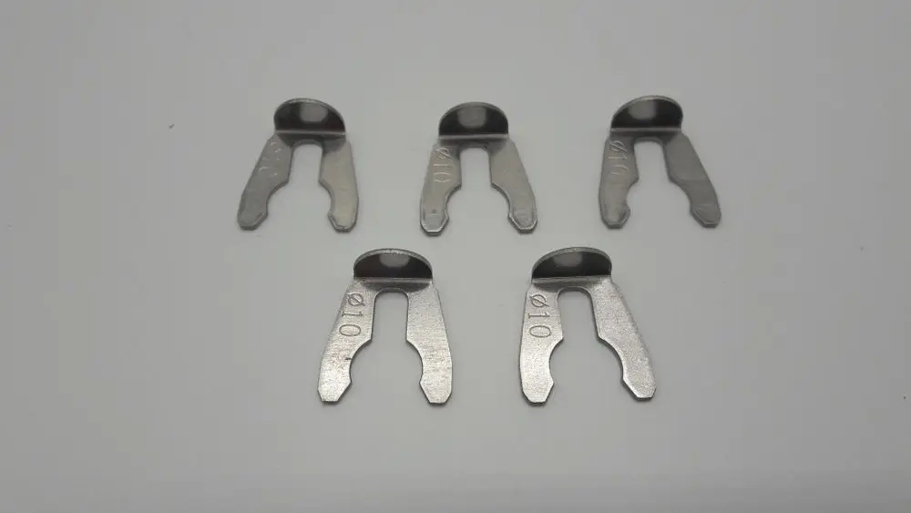 Fünf metallene Clips mit einer Öffnung, vermutlich zur Anwendung in Heizsystemen, markiert mit der Zahl "10", möglicherweise von der Marke Remeha.